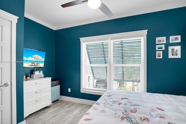 bedroom featuring ceiling fan, light hardwood / wood-style flooring, and ornamental molding