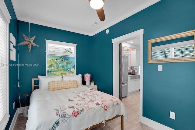 bedroom featuring light hardwood / wood-style floors, stainless steel fridge, and ceiling fan