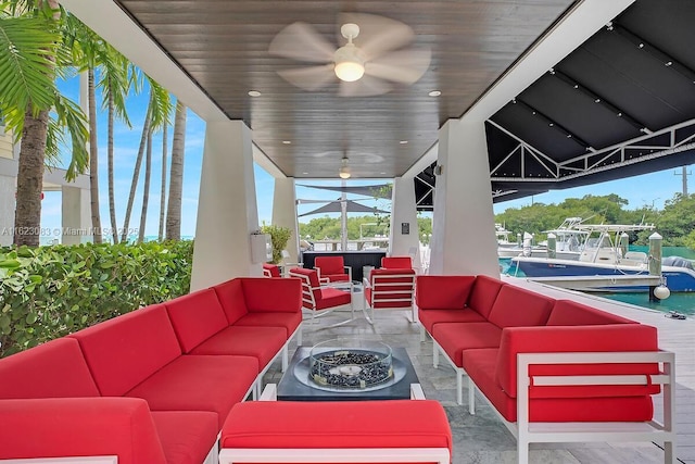 view of patio / terrace featuring ceiling fan and an outdoor living space with a fire pit