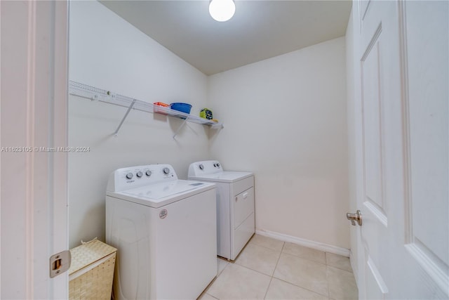 laundry room featuring light tile patterned floors, laundry area, washer and dryer, and baseboards