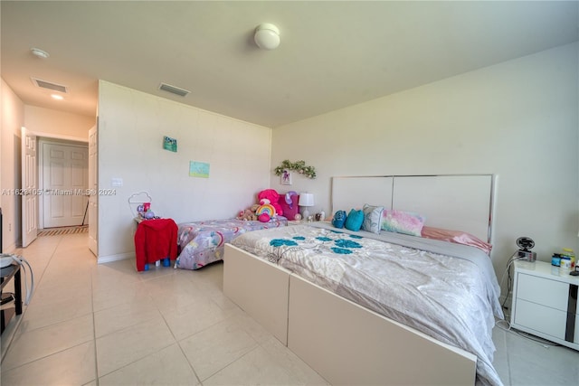 bedroom with light tile patterned floors and visible vents