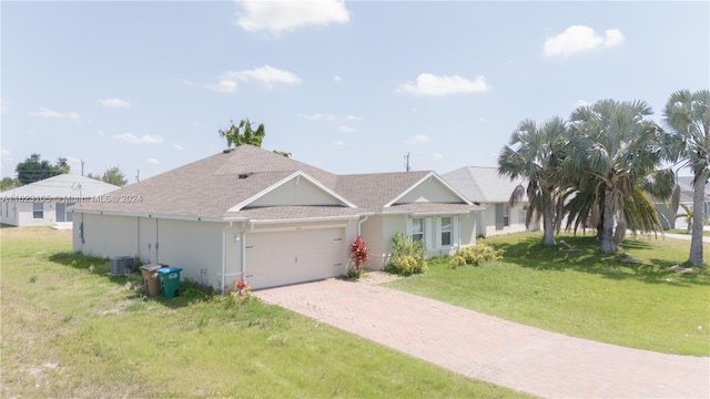 single story home with a front yard, an attached garage, central AC, stucco siding, and decorative driveway