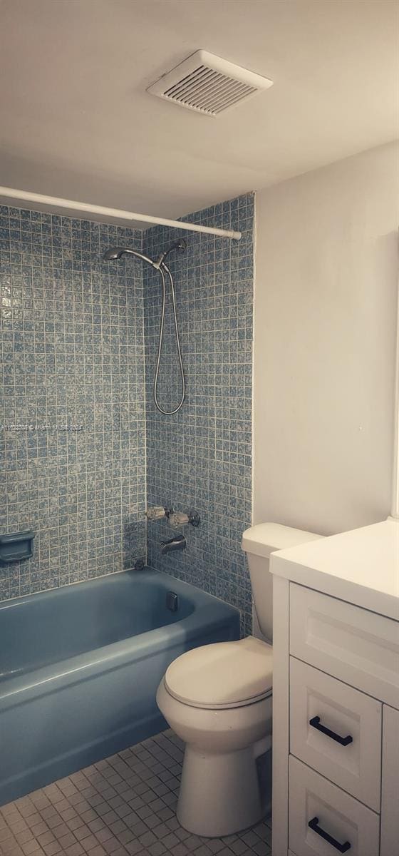 full bathroom with vanity, tiled shower / bath, tile patterned flooring, and toilet