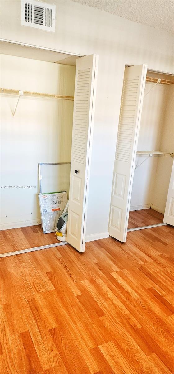 unfurnished bedroom with a textured ceiling and light wood-type flooring