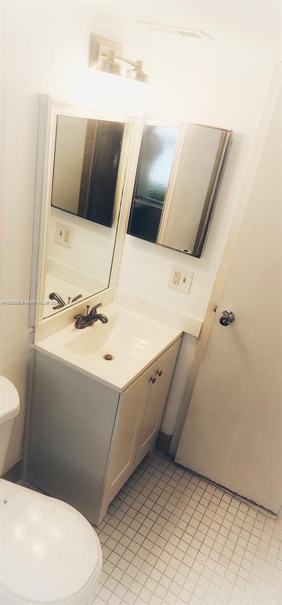 bathroom with vanity, tile patterned flooring, and toilet