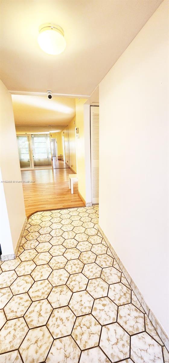 corridor with hardwood / wood-style flooring