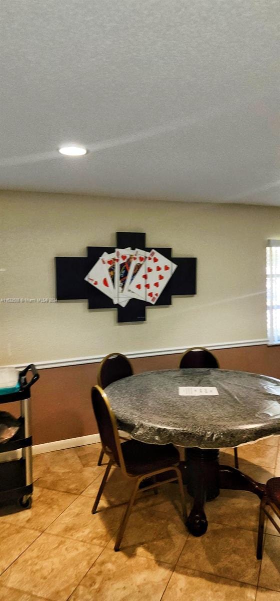 tiled dining area featuring a textured ceiling