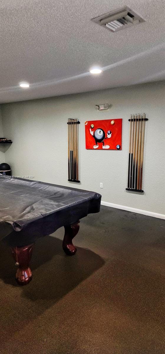 game room with dark carpet, billiards, and a textured ceiling