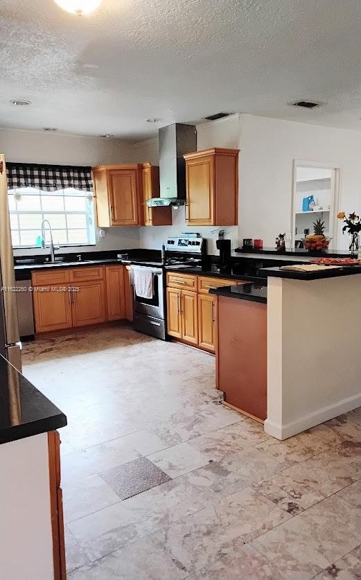 6474 SW 26th St, Miramar, FL 33023 - kitchen featuring stainless steel electric range, wall chimney exhaust hood, a textured ceiling, dark countertops, and freestanding refrigerator