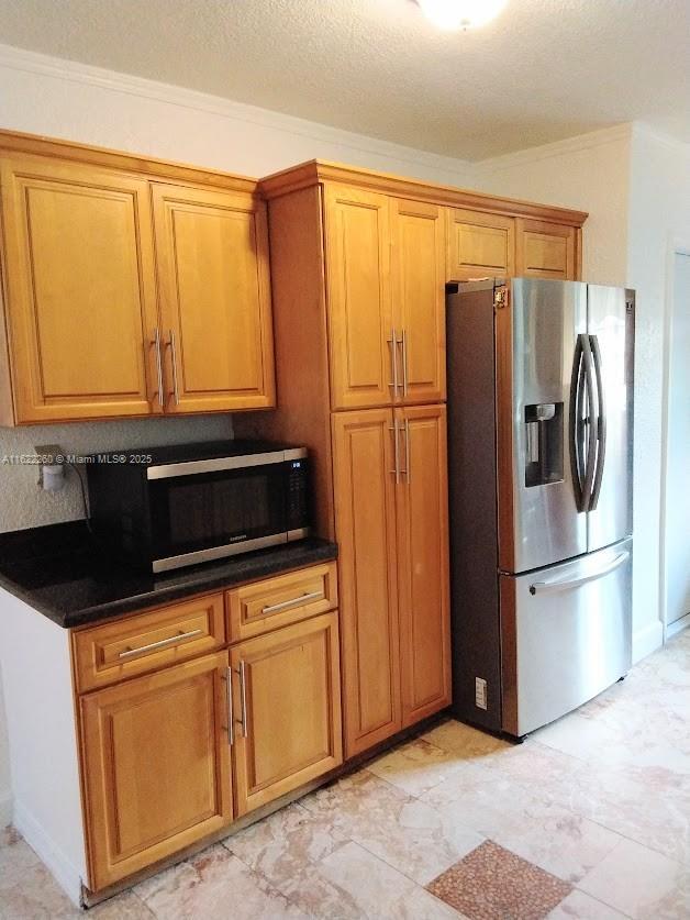 6474 SW 26th St, Miramar, FL 33023 - kitchen with stainless steel appliances, brown cabinets, crown molding, and dark countertops