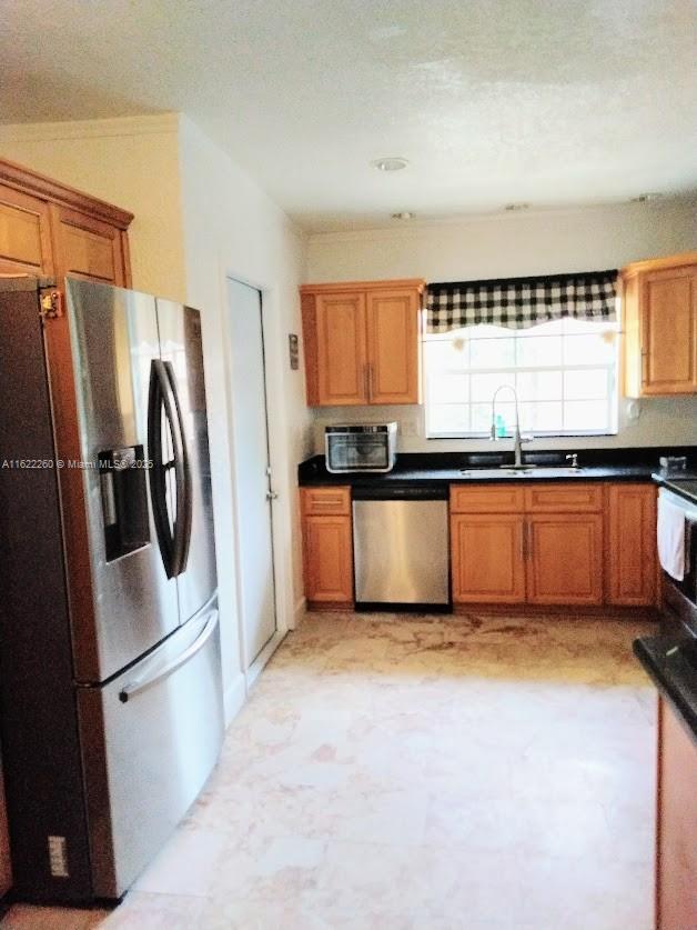 6474 SW 26th St, Miramar, FL 33023 - kitchen with appliances with stainless steel finishes, a sink, brown cabinets, and dark countertops