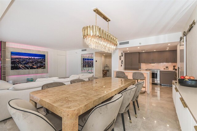 tiled dining room with a chandelier and a barn door