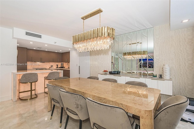 dining room with light tile patterned floors and a chandelier