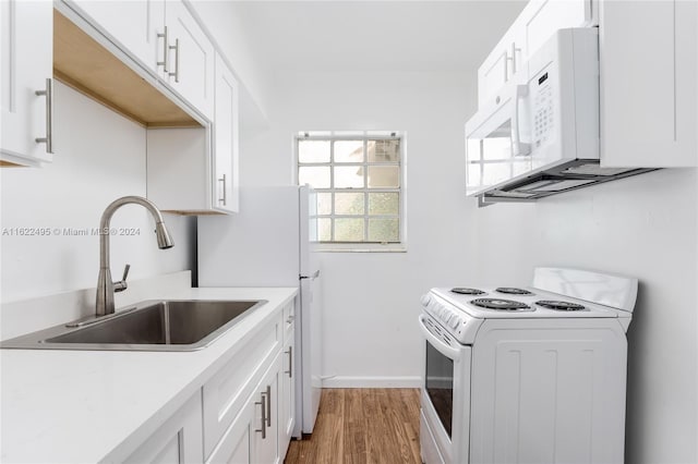 635 8th St Unit 205, Miami Beach, FL 33139 - kitchen featuring white appliances, light countertops, light wood finished floors, and white cabinets