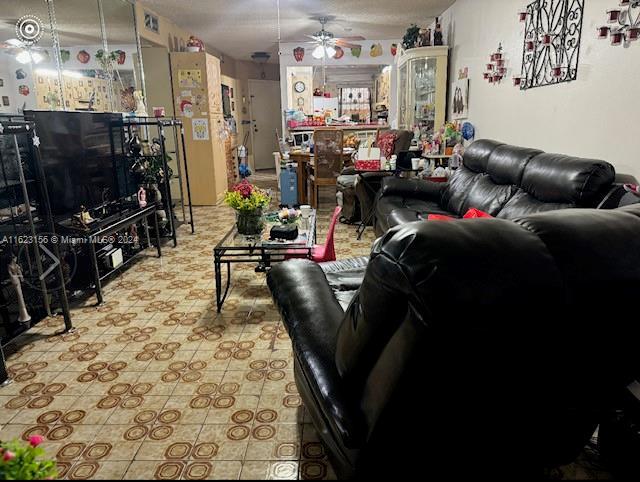 tiled living room featuring ceiling fan