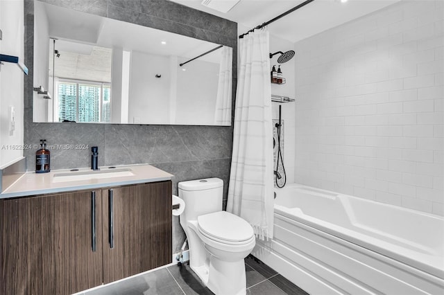 full bathroom featuring tile walls, vanity, shower / tub combo with curtain, toilet, and tile patterned floors