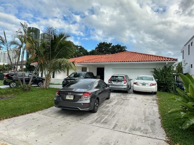 mediterranean / spanish house featuring a garage and a front yard