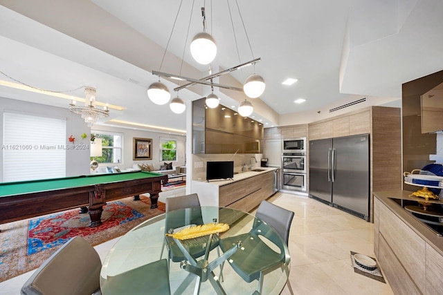 interior space with sink, hanging light fixtures, vaulted ceiling, appliances with stainless steel finishes, and pool table