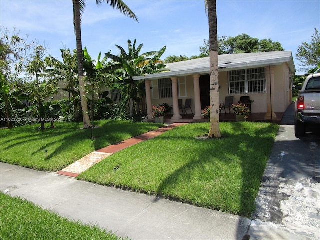 view of front of house featuring covered porch and a front lawn