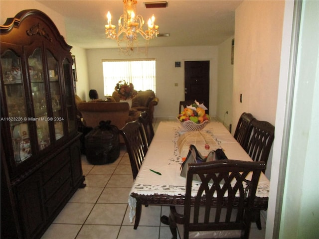 dining area with a chandelier and light tile patterned floors