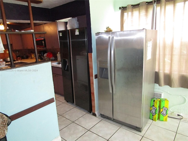 kitchen featuring light tile patterned flooring and black appliances