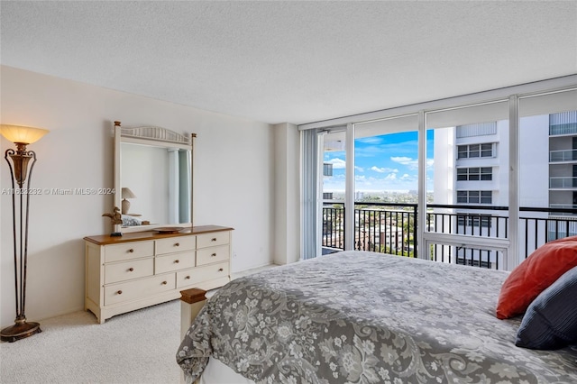 bedroom with light carpet, access to exterior, and a textured ceiling