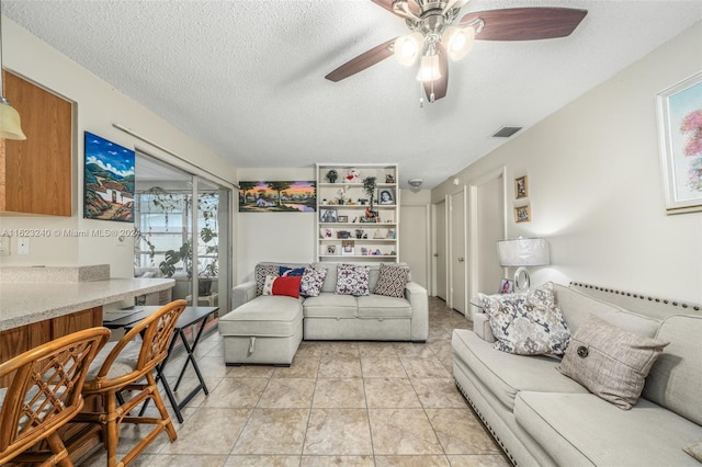 tiled living room with plenty of natural light, a textured ceiling, and ceiling fan