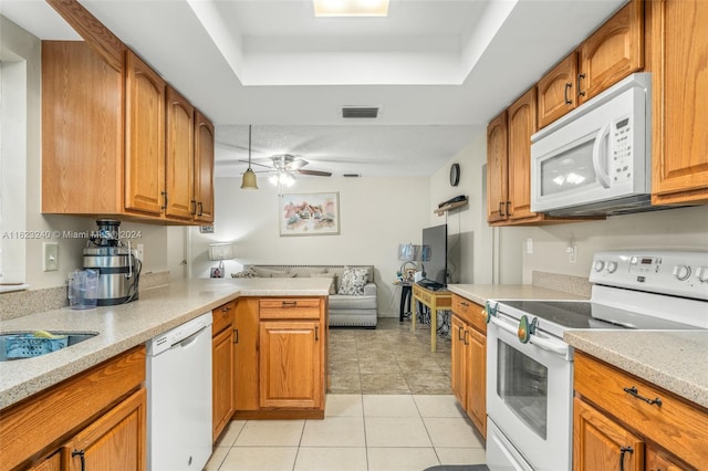 kitchen featuring a raised ceiling, ceiling fan, white appliances, and light tile patterned floors