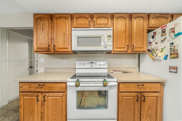 kitchen with tile patterned floors and white appliances