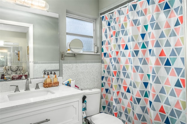 bathroom featuring decorative backsplash, tile walls, toilet, and vanity