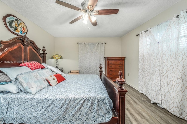 bedroom featuring a textured ceiling, wood-type flooring, and ceiling fan