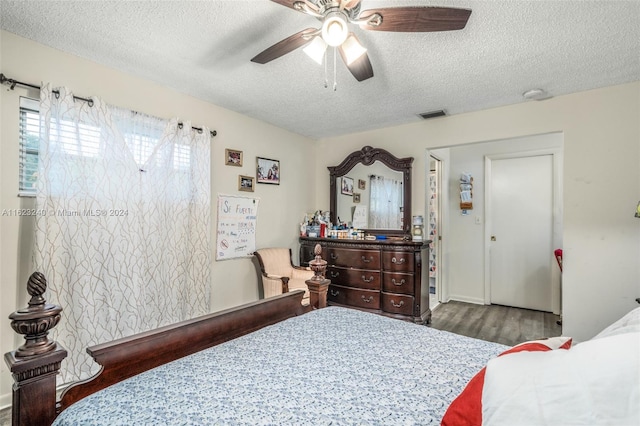 bedroom featuring a textured ceiling, ceiling fan, and dark wood-type flooring