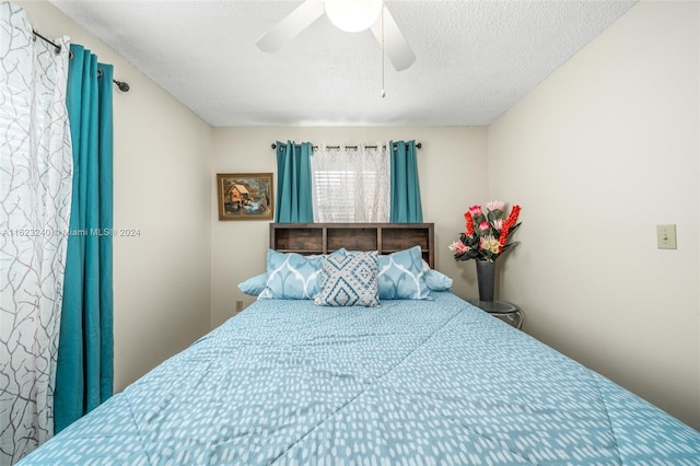 bedroom with a textured ceiling and ceiling fan