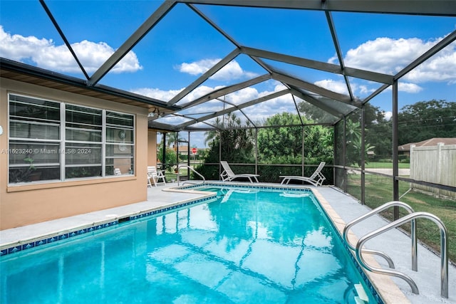 view of swimming pool with a patio area and glass enclosure