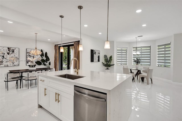 kitchen featuring sink, white cabinetry, hanging light fixtures, dishwasher, and a kitchen island with sink