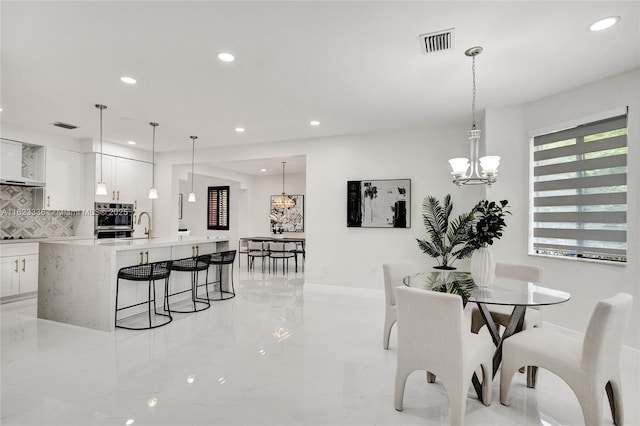 dining area with sink and a chandelier