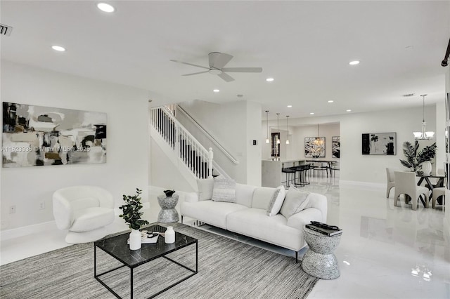 living room featuring ceiling fan with notable chandelier