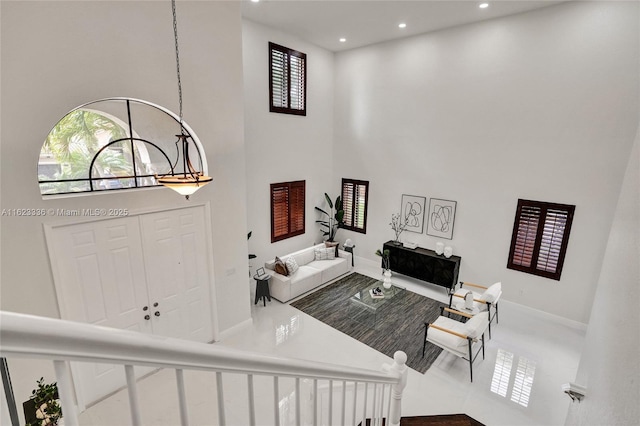 living room with a high ceiling, plenty of natural light, and a chandelier