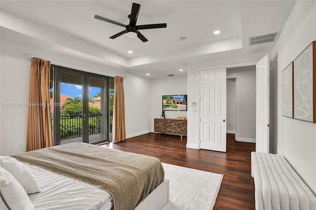 bedroom with dark hardwood / wood-style flooring, access to exterior, ceiling fan, a raised ceiling, and french doors