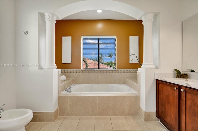 bathroom with decorative columns, a bidet, vanity, tiled tub, and tile patterned flooring