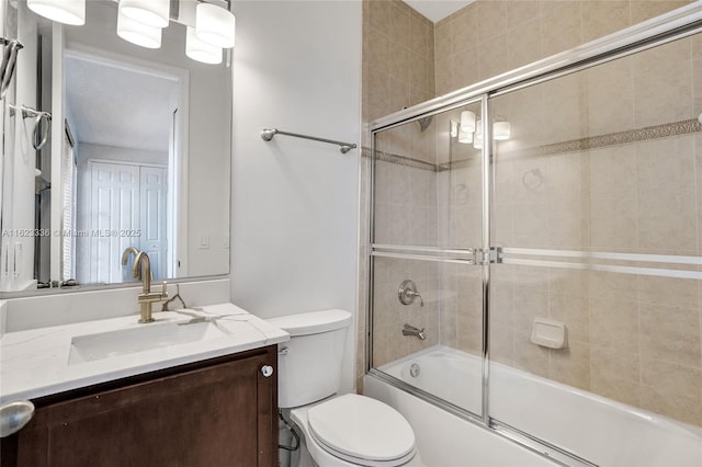 full bathroom featuring vanity, shower / bath combination with glass door, and toilet