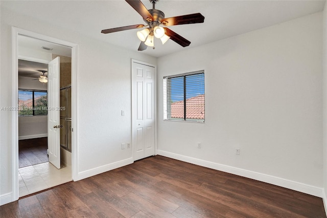 unfurnished bedroom with multiple windows, hardwood / wood-style floors, a closet, and ceiling fan