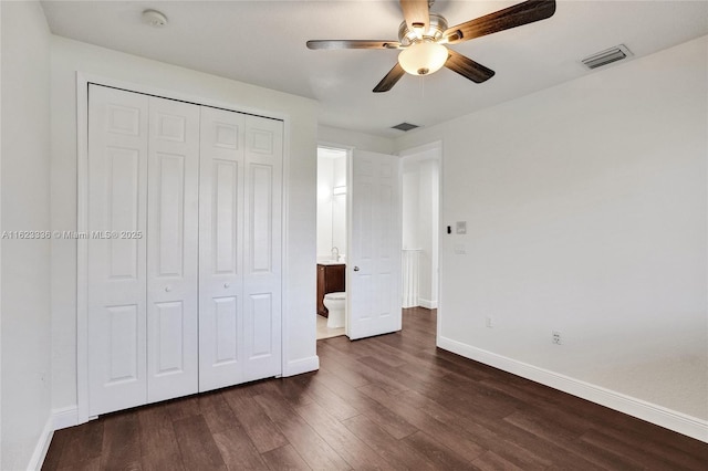 unfurnished bedroom with ceiling fan, dark hardwood / wood-style floors, and a closet