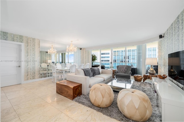 living area featuring a chandelier, marble finish floor, baseboards, and wallpapered walls