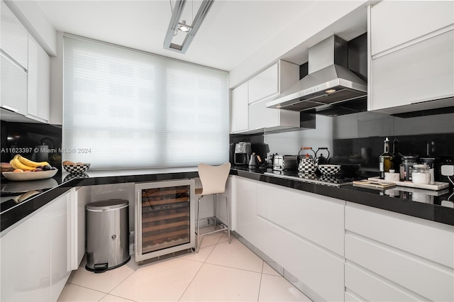 kitchen featuring white cabinets, dark countertops, wall chimney exhaust hood, modern cabinets, and light tile patterned flooring