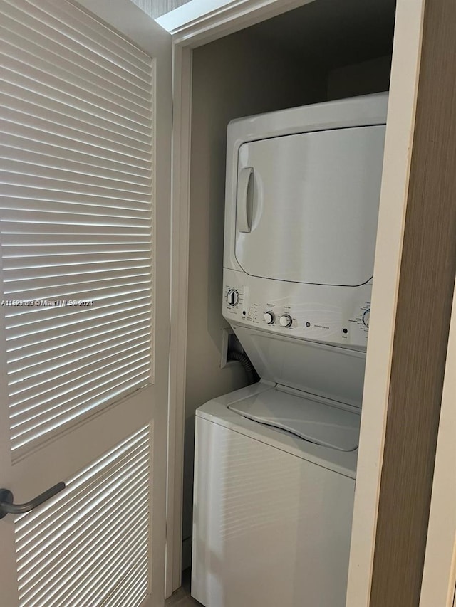 washroom featuring stacked washer / drying machine