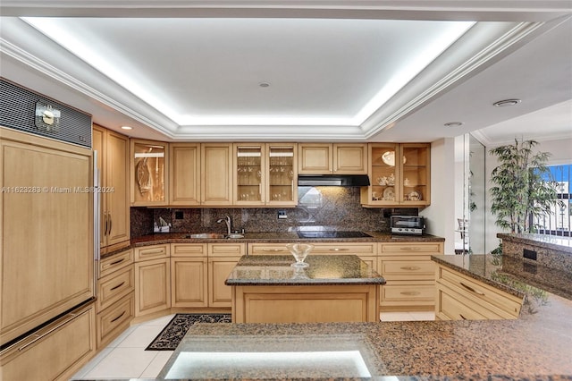 kitchen with dark stone counters, sink, light tile patterned floors, decorative backsplash, and a raised ceiling