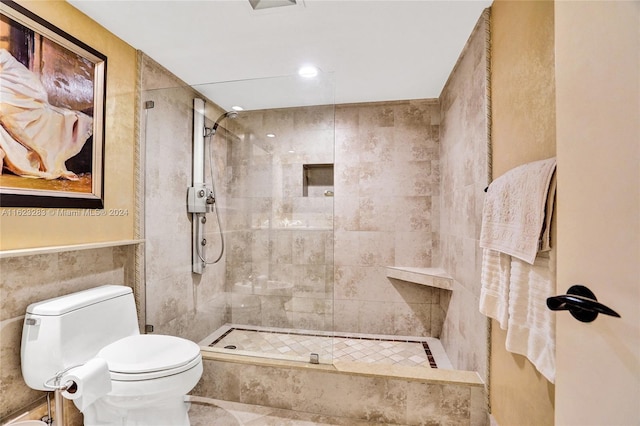 bathroom with tiled shower, tile walls, tile patterned flooring, and toilet