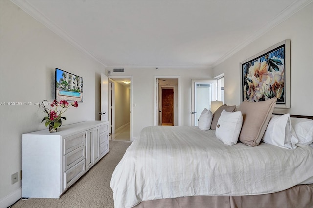 carpeted bedroom featuring ensuite bath and ornamental molding