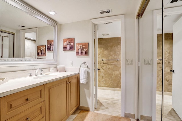 bathroom featuring vanity, tile patterned flooring, and walk in shower